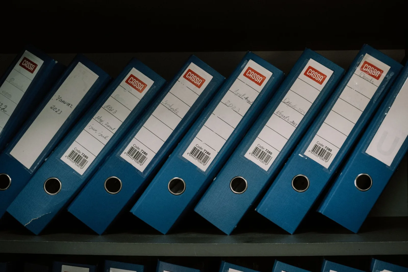 Rafta sıralanmış, sırtları etiketli dış ticaret dosya klasörleri